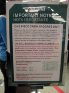 Tabellone dell'Alitalia che ricorda la limitazione di un bagaglio a mano consentito per l'imbarco e ne indica le dimensioni