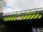 La scritta fosforescente ed il cartello che allertano i veicoli della bassezza del ponte